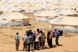 Jordanian workers take a UNHCR official on a walk around tents at the Zaatri refugee camp for Syrian refugees in Mafraq